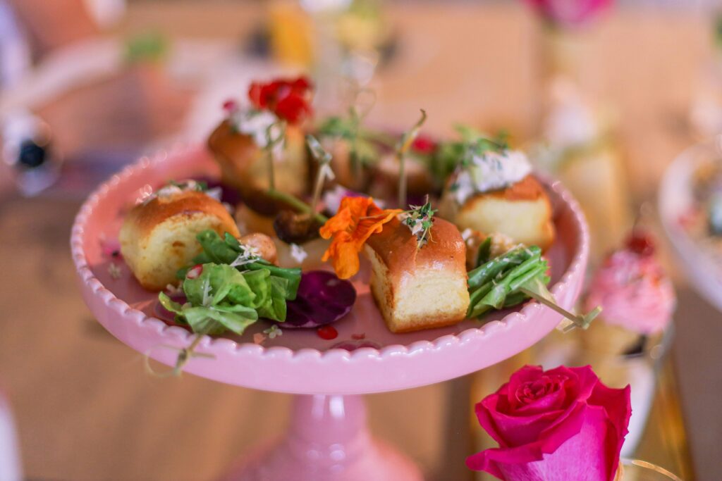 A colorful assortment of hapjes voor verjaardag bestellen, with skewers of cherry tomatoes and mozzarella, mini sandwiches, and bowls of mixed olives, set on a festive table."